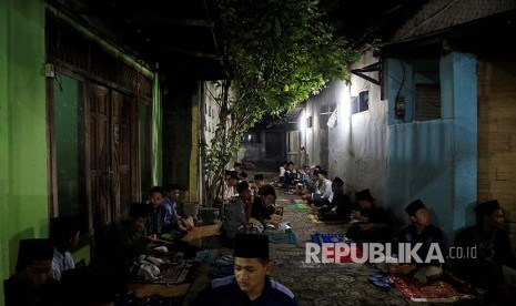 Santri Pesantren Lirboyo Kediri, Jawa Timur mempelajari Kitab Kuning di luar ruang pesantren pada bulan Ramadhan.