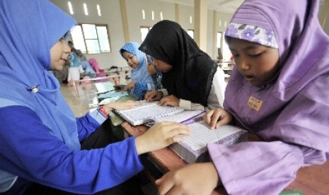 Santri sedang belajar membaca Alquran.