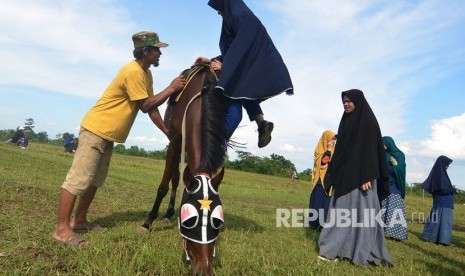 Santriwati bercadar dari Internasional Leader School (ILS) bersiap berlatih ekstrakurikuler olahraga berkuda di Gunung Kialir, Cibeurem, Kota Tasikmalaya, Jawa Barat, Rabu (28/2). 