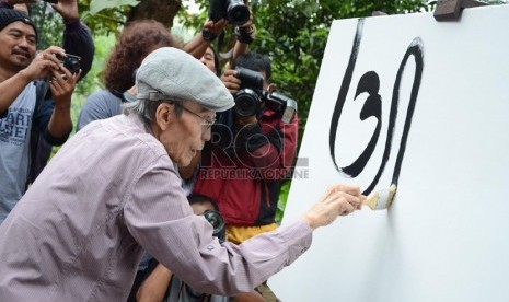   Sapardi Djoko Damono melukis kaligrafi dan aksara Jawa pada pembukaan pameran lukisan dan puisi 'Lima Rukun' di Studio Jeihan, Bandung, Sabtu (28/9). (Republika/Edi Yusuf)