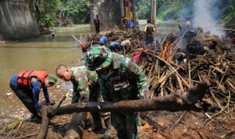 Satgas Banjir dari Dinas Bina Marga dan Sumber Daya Air Kota Depok bersama anggota Kodim 0508 membersihkan tumpukan sampah dan material kayu yang menghambat aliran sungai  (ilustrasi) 