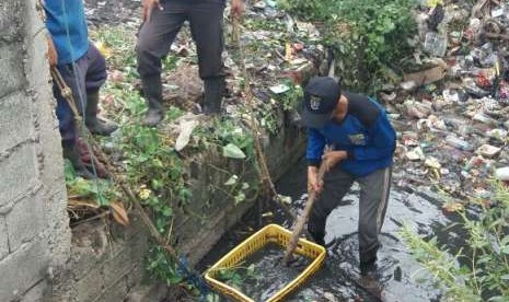 Petugas sedang membersihkan sampah yang berserakan akibat banjir (ilustrasi)