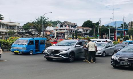 Satgas Covid-19 Kabuapten Bogor memeriksa surat hasil rapid test antigen terhadap wisatawan menuju kawasan Puncak, Kabupaten Bogor, Sabtu (16/1). 