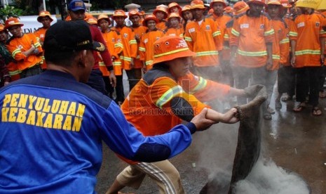  Satgas Kebakaran tengah berlatih menangani kebakaran di halaman Kelurahan Pekojan, Tambora, Jakarta Barat, Ahad (22/12).  (Republika/Yasin Habibi)