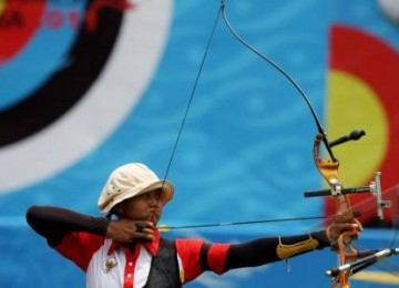 Satu dari tiga atlet panahan nomor recurve beregu putri, Ika Yuliana Rochmawati berkonsentrasi, membidik sasaran saat babak final SEA Games XXVI di Lapangan Panahan Senayan, Jakarta, Kamis (17/11). 