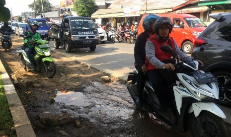 Satu ruas jalan yang rusak di Jalan Raya Lenteng Agung, Jakarta Selatan dibiarkan tanpa perbaikan.