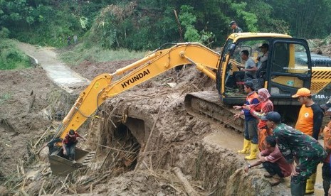 Satu unit alat berat dikerahkan untuk membersihkan jembatan yang tertimbun material longsor di Desa Santanamekar, Kecamatan Cisayong, Kabupaten Tasikmalaya, Sabtu (29/2). 