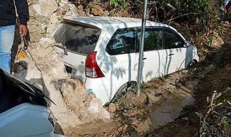 Satu unit mobil tertimbun material longsoran tanah dan batu di kawasan Kebun Kopi, kota Palu di Sulawesi Tengah, Sabtu (29/9). Longsor di area tersebut terjadi akibat gempa bumi pada Jumat (28/9) dan mengakibatkan jalur transportasi darat dari dan menuju kota Palu terhambat. 