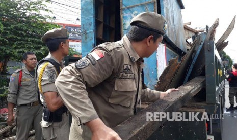 Satuan Polisi Pamong Praja (Satpol PP) Kota Tangerang Selatan tertibkan pedagang kaki lima (PKL) di sepanjang Jalan Raya Serpong, Pakulonan, Serpong Utara, Kota Tangerang Selatan, Jumat (28/4). 