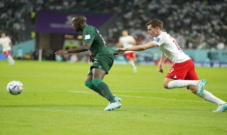  Saud Abdulhamid dari Arab Saudi ditarik oleh Jakub Kaminski dari Polandia selama pertandingan sepak bola grup C Piala Dunia antara Polandia dan Arab Saudi, di Stadion Education City di Al Rayyan, Qatar, Sabtu, 26 November 2022.