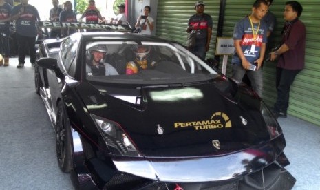 Sean Gelael (kanan) saat hendak mengemudikan Lamborghini Gallardo.