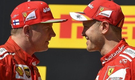 Sebastian Vettel (kanan) bersama rekan setimnya dari Ferrari Kimi Raikkonen setelah menjuarai GP Hungaria, Ahad (30/7).