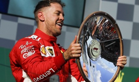 Sebastian Vettel mengangkat trofi juara GP Australia 2018, Ahad (25/3).