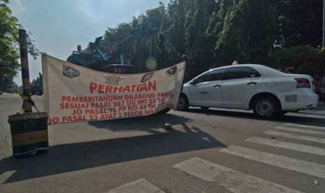 Sebnuah spanduk yang berisi mengenai larangan parkir terpasang di depan salah satu apartemen kawasan Kalibata, Jakarta Selatan, Selasa (2/9).  (Republika/Raisan Al Farisi)