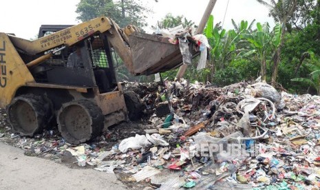 Sebuah alat berat amrol sedang mengangkut limbah medis yang tercampur dengan sampah biasa di tempat pembuangan sampah sementara di Desa Panguragan Wetan, Kecamatan Panguragan, Kabupaten Cirebon, Jumat (8/12). Limbah medis yang termasuk dalam bahan beracun dan berbahaya (B3) itu menumpuk di tempat tersebut.