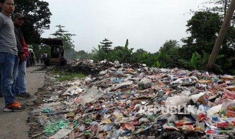 Sebuah alat berat amrol sedang mengangkut limbah medis yang tercampur dengan sampah biasa di tempat pembuangan sampah sementara di Desa Panguragan Wetan, Kecamatan Panguragan, Kabupaten Cirebon, Jumat (8/12). Limbah medis yang termasuk dalam bahan beracun dan berbahaya (B3) itu menumpuk di tempat tersebut.