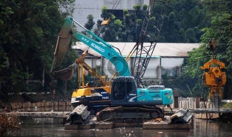 Sebuah alat berat memasang turap di Kali Ciliwung yang berada di Jalan Perwira, Jakarta Pusat, Kamis (3/7).(Republika/Raisan Al Farisi).