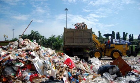  Sebuah alat berat mengangkut sampah yang menumpuk di pelataran Monumen Nasional, Jakarta Pusat, Senin (16/6).