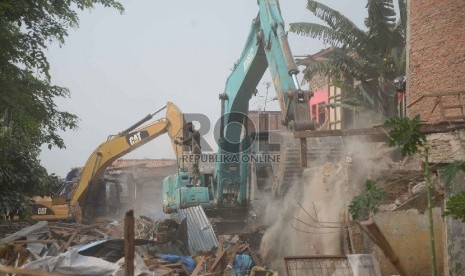 Sebuah alat berat merobohkan sejumlah bangunan permukiman padat di bantaran sungai Ciliwung di Kampung Pulo, Kampung Melayu, Jatinegara, Jakarta, Jumat (21/8).