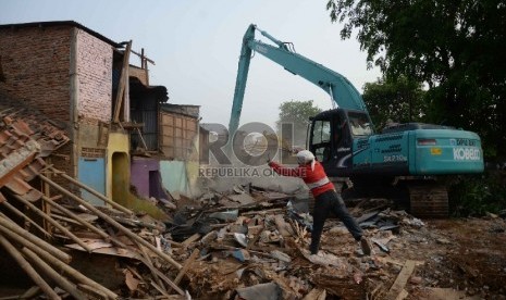 Sebuah alat berat merobohkan sejumlah bangunan permukiman padat di bantaran sungai Ciliwung di Kampung Pulo, Kampung Melayu, Jatinegara, Jakarta, Jumat (21/8). 