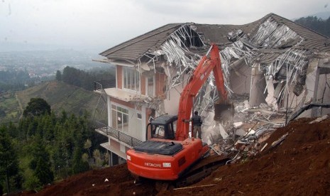   Sebuah alat berat yang sedang melakukan pembongkaran villa liar di Desa Tugu Utara, Cisarua, Bogor, Jabar, Senin (25/11).  (Antara//Jafkhairi)