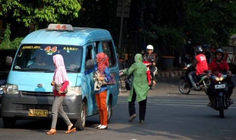 Sebuah angkot jurusan Kampung Melayu - Karet menurunkan penumpang di sembarangan di kawasan Tebet, Jakarta Selatan, Senin (23/6).