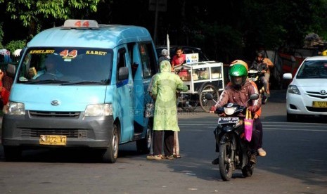 Sebuah angkot jurusan Kampung Melayu - Karet menurunkan penumpang di sembarangan di kawasan Tebet, Jakarta Selatan, Senin (23/6).