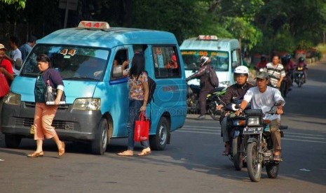 Sebuah angkot jurusan Kampung Melayu - Karet menurunkan penumpang di sembarangan di kawasan Tebet, Jakarta Selatan, Senin (23/6).