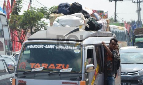  Sebuah angkutan umum minibus Elf jurusan Priangan Timur dengan muatan yang melebihi kapasitas melintas di jalan Rancaekek, Kabupaten Bandung, Ahad (4/8).  (Republika/Edi Yusuf)