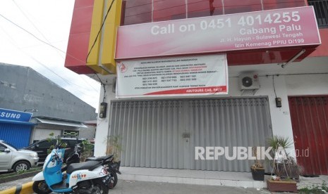 Sebuah baliho bertuliskan kantor diistirahatkan sementara waktu sampai situasi kembali kondusif yang ditujukan kepada seluruh anggota jamaah, agen serta mitra, terpasang di depan Kantor Abu Tours Cabang Palu di Jalan H Hayun Palu, Sulawesi Tengah. 