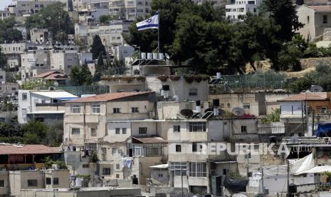 Sebuah bendera Israel berkibar di atas rumah milik Yahudi di lingkungan Palestina 