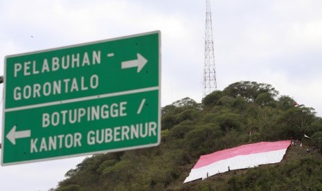 Sebuah bendera merah putih raksasa berukuran 30x30 meter dibentangkan di bukit Dumbo, Kota Gorontalo, Selasa (16/8). 