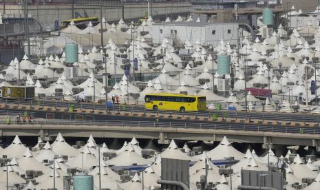 Sebuah bus yang membawa jamaah haji melewati kamp tenda Mina selama haji, di Mekah, Arab Saudi, Kamis, 7 Juli 2022. Satu juta peziarah dari seluruh dunia berkumpul pada hari Kamis di kota suci Mekah di Arab Saudi untuk melakukan ritual awal haji, menandai ziarah Islam terbesar sejak pandemi virus corona membatalkan acara tahunan – pilar utama Islam. 