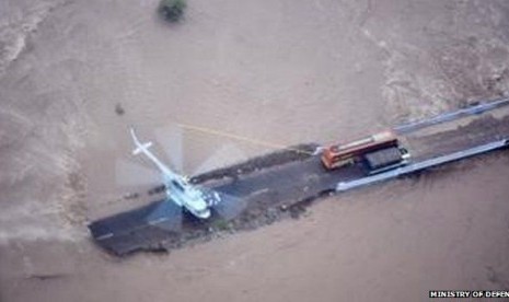 Sebuah helikopter Angkatan Udara India menyelamatkan penumpang bus yang terjebak banjir di Gujarat, India, Kamis (25/6).