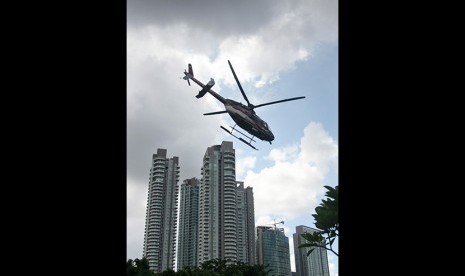 Sebuah helikopter melintasi gedung apartemen di Jakarta.  (ilustrasi)