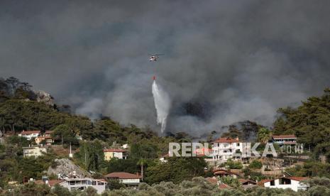  Sebuah helikopter mengebom kebakaran hutan yang membakar di daerah pedesaan distrik Marmaris di Mugla, Turki, 31 Juli 2021. Menurut pernyataan dari Kepresidenan Manajemen Bencana dan Darurat (AFAD) pemerintah Turki yang dirilis pada 30 Juli 2021, setidaknya tiga orang kehilangan nyawa mereka. nyawa dan sekitar 271 lainnya terkena dampak kobaran api yang melanda pantai selatan negara itu. 