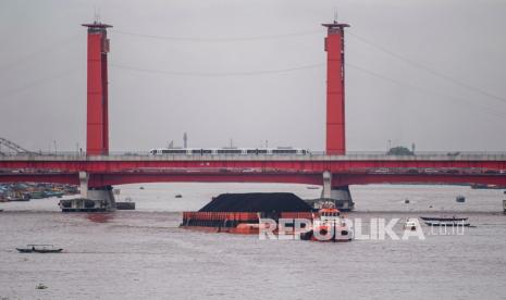 Sebuah kapal tongkang pengangkut batu bara melintas di Sungai Musi, Palembang, Sumatera Selatan, Rabu (24/11/2021). Pemerintah Kota Palembang berencana memungut retribusi sebesar Rp4 ribu per ton kepada angkutan batu bara yang melintas di Sungai Musi yang akan diterapkan mulai tahun 2022 mendatang.