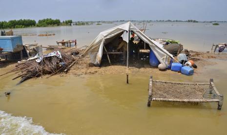  Sebuah keluarga duduk di bawah tenda di samping rumah mereka yang hancur, dikelilingi oleh air banjir, di Sohbatpur, sebuah distrik di provinsi Baluchistan barat daya Pakistan, Senin, 29 Agustus 2022. Bantuan internasional mencapai Pakistan pada hari Senin, ketika militer dan sukarelawan mati-matian mencoba untuk mengevakuasi ribuan orang yang terdampar oleh banjir yang meluas didorong oleh monsoon monster yang telah merenggut lebih dari 1.000 nyawa musim panas ini.