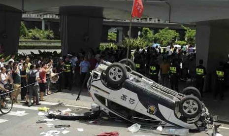   Sebuah kendaraan polisi merk Honda dirusak massa dalam aksi unjuk rasa anti Jepang di Shenzen, Cina, Ahad (19/8). 