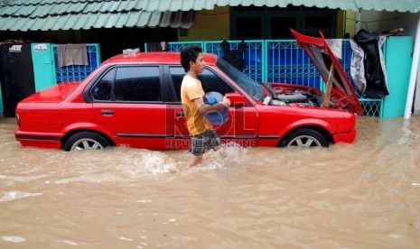  Sebuah kendaraan terendam air di Kampung Poncol, Kelurahan Bukit Duri, Kecamatan Tebet, Jakarta Selatan, Senin (24/12). (Republika/Prayogi)