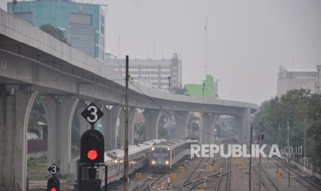 Sebuah kereta api Railink bandara Kualanamu melintas dengan latar belakang kota Medan yang diselimuti kabut asap (ilustrasi)