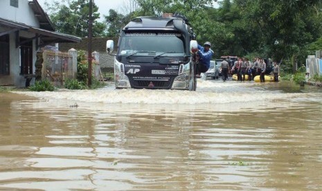 Sebuah mobil angkutan nekat menerobos jalan yang sudah tergenang air  Waduk Jatigede, Kabupaten Sumedang, Senin (15/2).  (foto : MgBDG_MJ05)