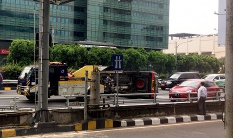 Sebuah mobil bertuliskan 'Teknisi Bom' dan dikawal oleh Patwal, terguling di tol dalam kota depan Halte Busway Lipi Gatot Soebroto, Selasa (10/7) pukul 10.30 WIB.