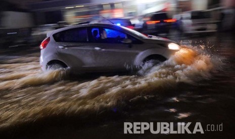 Sebuah mobil berusaha menerobos banjir di Kawasan Kemang, Ahad (28/8). (Foto: Yogi Ardhi/Republika)