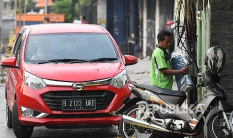 Sebuah mobil dan sepeda motor diparkir di trotoar kawasan Cikini, Jakarta, Selasa (5/11/2019).