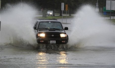 Sebuah mobil harus melewati genangan air yang tinggi di wilayah Ocean View di Norfolk, Virginia, Amerika Serikat (AS). Hujan dan angin yang disebabkan Badai Sandy telah menyerang sepanjang wilayah timur laut AS.