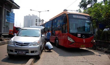  Sebuah mobil minibus tersangkut di pembatas jalur busway Kawasan Jalan Gunung Saharai Raya, Jakarta Utara, Selasa (22/7). (Republika/Raisan Al Farisi)