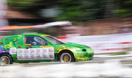 Sebuah mobil peserta melaju dengan kecepatan tinggi dalam kejuaraan Drag Race terbuka