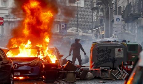 Sebuah mobil polisi dibakar saat fans Napoli berulah mengintimidasi suporter Eintracht Frankfurt di Naples, Italia, Rabu (15/3/2023), menjelang pertandingan leg kedua babak 16 besar Liga Champions antara SSC Napoli dan Eintracht Frankfurt. 