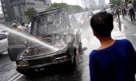  Sebuah mobil sedan terbakar di kawasan Bundaran Hotel Indonesia, Jakarta, Jumat (8/11).  (Republika/Prayogi)